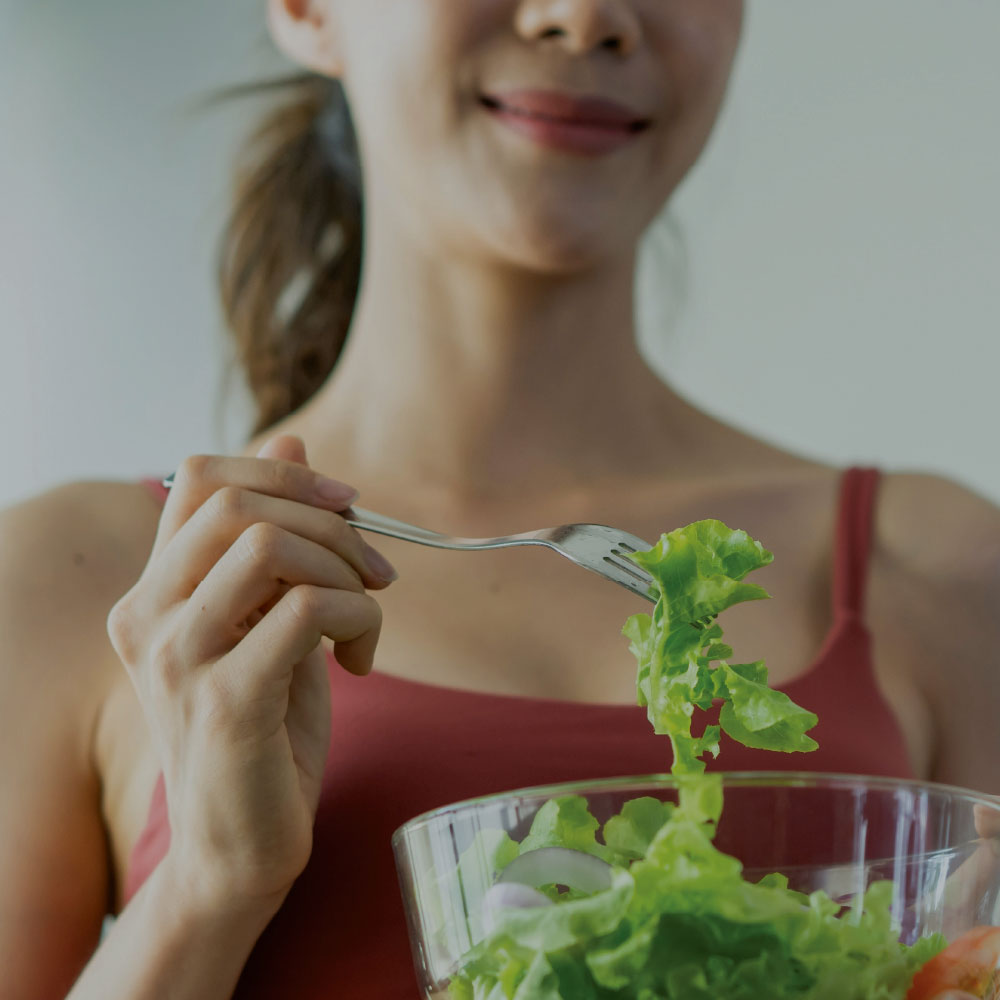 Woman eating a bowl of salad