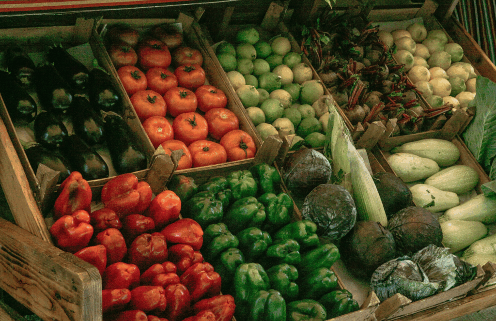 anti-inflammatory grocery list produce including tomatoes, peppers, eggplant, cabbage, and squash at a market