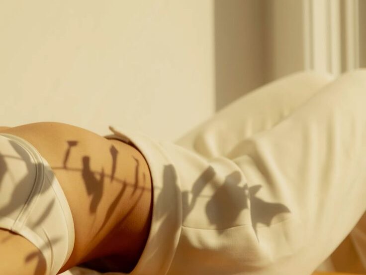 Woman resting in warm natural light, symbolizing relaxation, stress balance, and overall hormonal well-being.