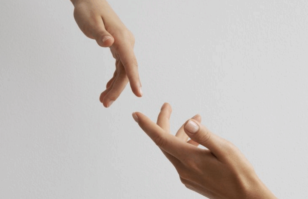 A close-up of two hands reaching toward each other against a soft neutral background, symbolizing support, connection, and guidance for people navigating interstitial cystitis.