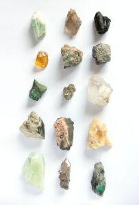 Assorted mineral specimens displayed on a white background, representing essential minerals that support women's health, energy, bone health, and cognitive function.