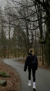 Woman walking outdoors on a cold winter day, representing how colder weather and seasonal conditions may influence respiratory infections, colds, and flu.